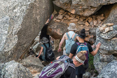 Hikers descending through a narrow boulder passage below Wolfberg Cracks in the Cederberg Wilderness Area near Sanddrif, Western Cape, South Africa.