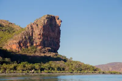 Towering sandstone cliff rises above the Hunter River estuary and mangrove-lined shoreline in the Kimberley.