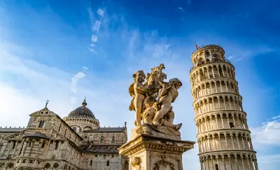 The Leaning Tower of Pisa beside the cathedral and statues in Piazza dei Miracoli, Pisa, Italy.