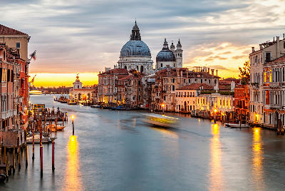 Twilight view of the Grand Canal in Venice, with fading light reflecting on the water and historic buildings.