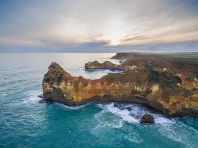 Aerial view of rugged limestone cliffs and turquoise ocean near Childers Cove on Victoria’s Great Ocean Road.