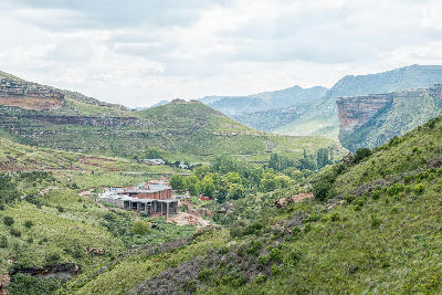 Landscape view across the valleys of Golden Gate Highlands National Park with green hills, layered sandstone cliffs and Brandwag Buttress rising above the surrounding highlands.