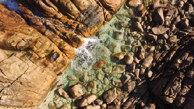 Aerial view of swimmers in the clear rock pool at Injidup Natural Spa, Yallingup, Western Australi