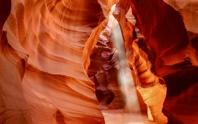 Light beam illuminating curved sandstone walls inside Antelope Canyon, Arizona