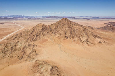 Aerial view of rugged desert mountains and open plains near Sesriem in Namib-Naukluft National Park, Namibia.