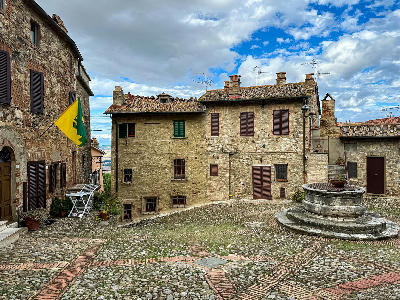 Piazza del Vecchietta in Castiglione d’Orcia, featuring a 16th-century stone well in the historic centre of Val d’Orcia, Tuscany, Italy.