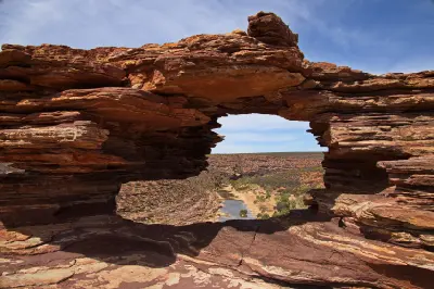 Layered red sandstone of Nature’s Window frames the Murchison River winding through the gorge below.