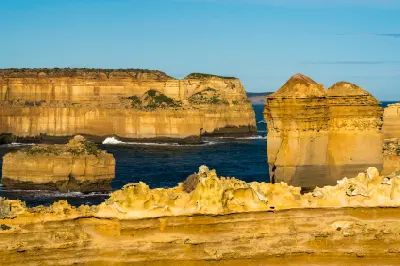 Golden limestone cliffs and offshore sea stacks along the Port Campbell and Shipwreck Coast in Victoria.