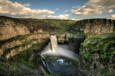 Long-exposure photograph of Palouse Falls flowing into a circular plunge pool within a basalt canyon in Washington State