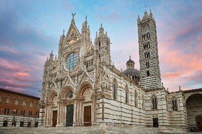 The richly decorated façade of Siena Cathedral (Duomo di Siena) and its striped campanile rising above the Piazza del Duomo in the historic Tuscan city of Siena.