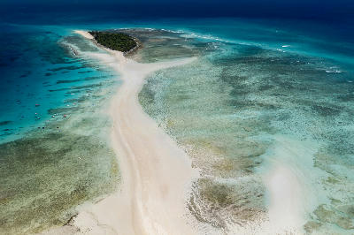 Aerial view of the Nosy Iranja Sandbar near Nosy Be in Madagascar with white tidal sandbanks, shallow turquoise lagoons, coral reef textures, and tropical island vegetation
