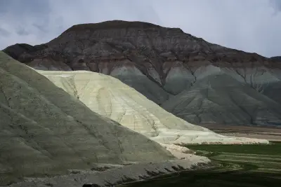 Layered green, cream and reddish hills at Kız Tepesi Nature Monument in Türkiye.