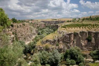 Rocky cliffs and dense vegetation along the Melendiz River in Ihlara Valley, Turkey.
