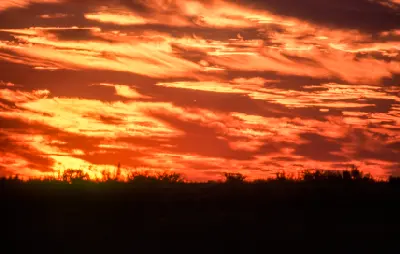 Fiery orange and red sunset clouds above Deception Valley in the Central Kalahari Game Reserve, Botswana.