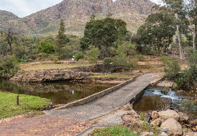 Low-water bridge crossing the Palmiet River at Algeria in the Cederberg Mountains, surrounded by indigenous trees and rugged sandstone cliffs in the Western Cape, South Africa.