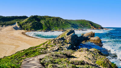 View of Robberg Peninsula near Plettenberg Bay showing rocky coastline, beach, fynbos hills and Indian Ocean scenery on the Garden Route.
