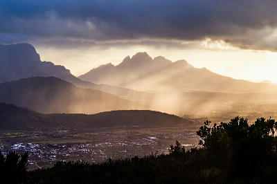 Dramatic sunset rainfall over Franschhoek Valley and Simonsberg mountain in the Cape Winelands of South Africa.