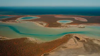 Aerial view of turquoise lagoons, tidal channels and red arid coastline at Shark Bay, Western Australia.