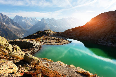 Turquoise Lac Blanc lake with surrounding rocky terrain and Mont Blanc peaks in the background near Chamonix in the French Alps.