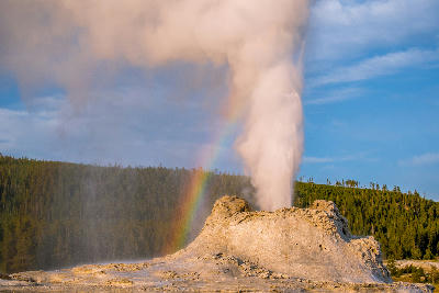 Castle Geyser eruption Yellowstone Upper Geyser Basin rainbow steam plume golden hour