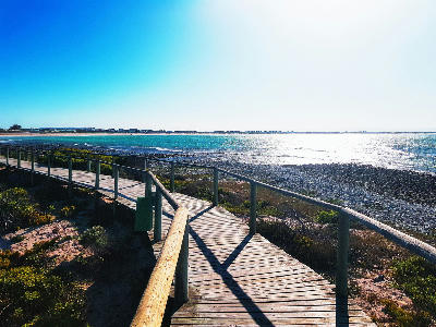 Wooden coastal boardwalk overlooking the rocky shoreline and turquoise ocean near Struisbaai and Cape Agulhas in the Western Cape, South Africa.