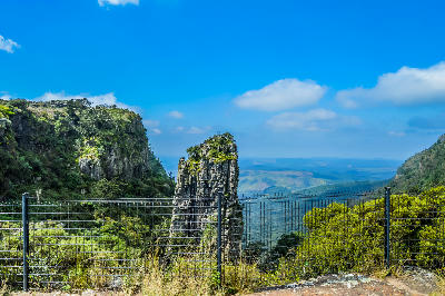 Viewing platform and safety fence overlooking Pinnacle Rock and the forested escarpment gorge near Graskop, Mpumalanga, South Africa.