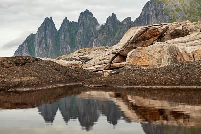 Tidal pool reflection of Okshornan mountains from Tungeneset coastal rocks, Senja
