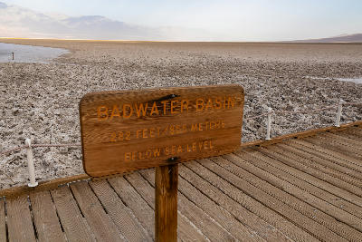 Badwater Basin sign showing 282 feet below sea level in Death Valley National Park California with salt flats landscape in background