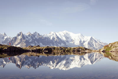 Runner beside Lac Blanc with clear reflections of Mont Blanc and surrounding peaks in the French Alps near Chamonix.