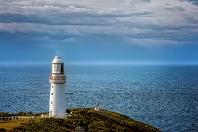 Cape Otway Lighthouse standing above the Southern Ocean beneath dramatic clouds in Victoria, Australia.