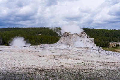 Castle Geyser sinter cone steaming Upper Geyser Basin Yellowstone cloudy sky