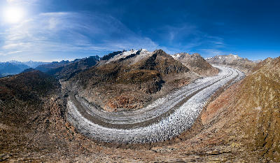 Panoramic view of the Great Aletsch Glacier curving through alpine ridges in Valais, Switzerland.