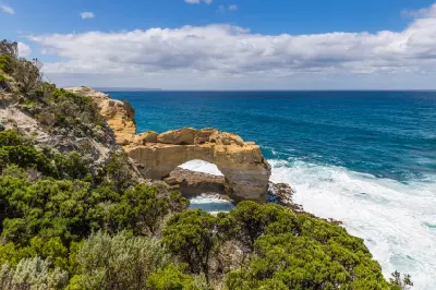 Wide coastal view of The Arch surrounded by native vegetation on Victoria’s Great Ocean Road.