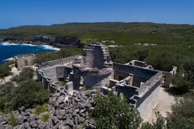 Stone ruins of Cape St George Lighthouse overlooking the rugged coastal cliffs and blue ocean of Jervis Bay Territory.
