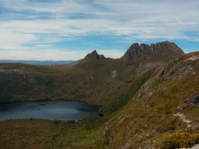 Panoramic view of Cradle Mountain above a glacial lake and rugged alpine landscape in Tasmania, Australia.
