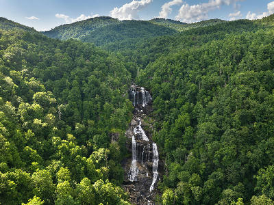Tall multi-tiered Whitewater Falls surrounded by lush green Appalachian forest in western North Carolina.