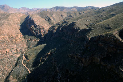 Aerial landscape view of Swartberg Pass cutting through rugged canyon terrain between Oudtshoorn and Prince Albert in the Klein Karoo of South Africa.
