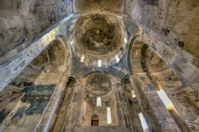 Interior of Holy Cross Church on Akdamar Island showing its stone domes, arches and surviving medieval Armenian frescoes.