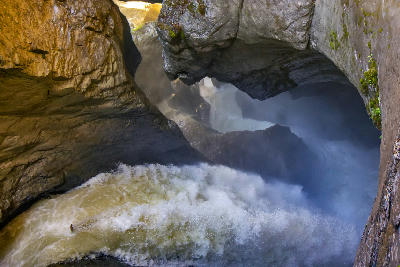 Powerful glacier-fed water rushing through a narrow cavern at Trümmelbach Falls, carving smooth rock walls inside the mountain in Lauterbrunnen Valley, Switzerland.