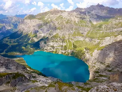 Oeschinensee from above, with turquoise water beneath steep alpine cliffs in the Bernese Alps, Switzerland.