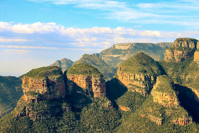 The Three Rondavels rock formations rising above the Blyde River Canyon in Mpumalanga, South Africa, with layered sandstone cliffs and canyon scenery in the background.