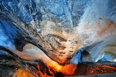 Water rushing through a smooth, sculpted rock tunnel at Trümmelbach Falls, with blue-toned stone and warm reflected light inside the cavern in Lauterbrunnen Valley, Switzerland.