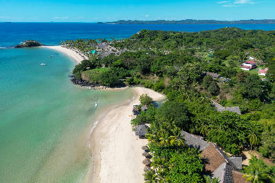 Drone view of Andilana Beach on Nosy Be in Madagascar showing tropical shoreline, white sand beaches, and turquoise coastal water.