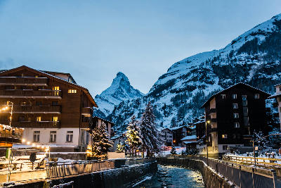 Zermatt village street and river channel in winter with the Matterhorn rising above the settlement, Switzerland.