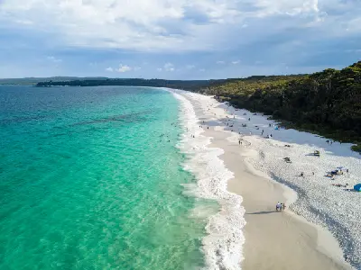 Brilliant turquoise water meets the sweeping white sands of Hyams Beach, backed by dense coastal bushland in Jervis Bay.
