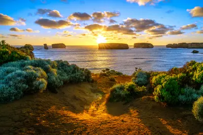 Limestone sea stacks silhouetted against a golden sunset at Bay of Islands, Victoria, Australia.