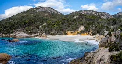 Panoramic view of turquoise water, white sand and granite hills at Little Beach in Two Peoples Bay Nature Reserve near Albany, Western Australia.