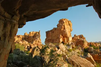 View from inside Stadsaal Cave towards sandstone cliffs and boulder-strewn landscapes in the Cederberg Wilderness Area, Western Cape, South Africa.
