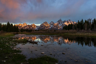 Sunrise reflection of the Teton Range in the Snake River at Schwabacher Landing with rocks in the foreground