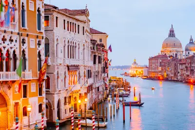 Warm illuminated lights at sunset in Venice, reflecting off canals and historic buildings.
